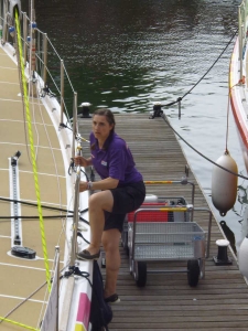 Photograph of Ruth climbing aboard the yacht from a wooden pontoon